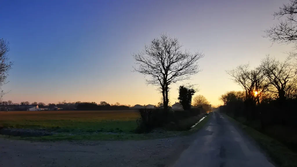 Chemin de campagne en hiver, au lever du jour, illustrant un défi de course à pied quotidien