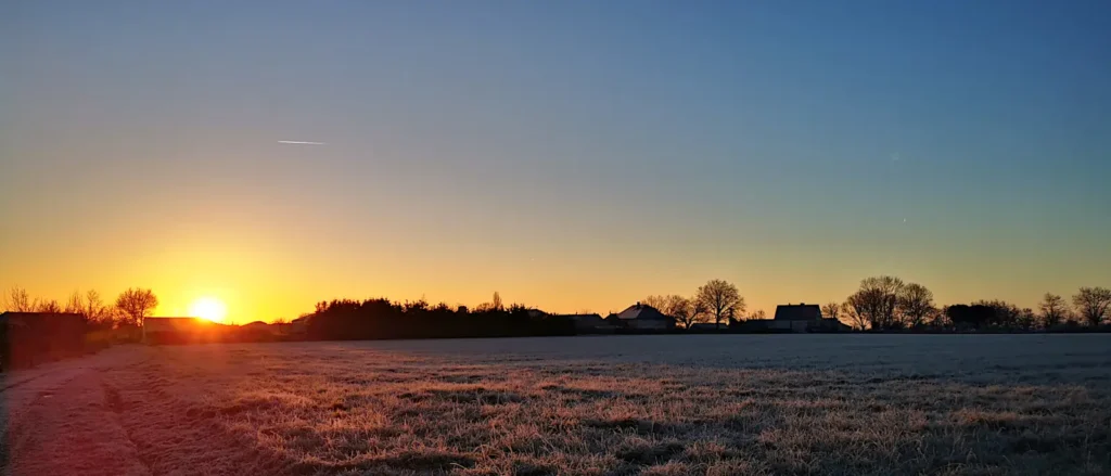 Lever de soleil hivernal sur les champs lors du bilan du défi 10 km par jour